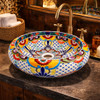 Talavera vessel Mexican bathroom sink floral lattice design in a restaurant restroom with warm lighting and decorative tiles