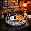 Talavera vessel Mexican bathroom sink sun moon design in a restaurant restroom with artistic decor and ambient lighting