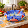 Blue dotted talavera vessel Mexican bathroom sink design in kitchen sink on tile countertop with natural light