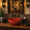 Red petal talavera vessel sink round bathroom installed in a restaurant restroom with decorative tile and warm ambiance