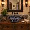 Talavera vessel sink round blue floral design in a bathroom vanity with warm wood and natural light