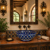 Talavera vessel sink round blue floral design in a hacienda interior with textured walls and wood beams