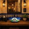 Talavera vessel sink round floral lattice design in a restaurant restroom with rustic decor and warm ambiance
