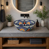 Mexican talavera round floral blue bath sink placed in a modern bathroom with clean lines and stone countertop