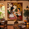 Talavera tile mural calla lilies sunflowers in a Mexican restaurant with rustic tables and pottery.