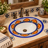 Oval Mexican floral lattice with white bottom bathroom sink in a rustic wood vanity setting