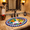 Oval talavera bathroom sink colorful fish design in Spanish Revival bathroom with tile vanity and iron mirror