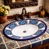Mexican oval talavera blue floral bathroom sink in a Spanish Revival bathroom with tile and wrought iron details