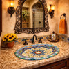 Oval mexican talavera floral starburst bathroom sink in a Spanish Revival bathroom with wrought iron mirror and tile accents