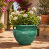 Rustic green Talavera planter filled with greenery on a Mediterranean garden terrace