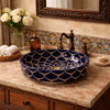 Talavera radial navy floral above counter Bbathroom sink in a Spanish style bathroom vanity with warm tones and handcrafted tile accents