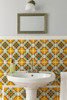 Yellow red medallion talavera tile used above a bathroom vanity highlighting Mexican handcrafted design