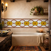 Mexican yellow flor over white relief border talavera tile in a rustic bathroom wall