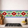 Mexican talavera floral relief border tile installed as kitchen backsplash accent beneath cabinetry