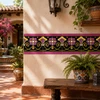 Mexican talavera black floral relief border tile on a hacienda patio with stucco and greenery