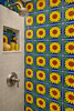 Sunflower folk mexican talavera tile used inside a bathroom shower creating a bold handcrafted focal wall