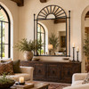 Wrought iron sunburst mirror in Spanish Revival design featured in a rustic living room