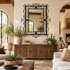 Rectangular ornate wrought iron mirror with scrollwork frame in an elegant living room