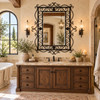Rectangular ornate wrought iron mirror with scrollwork frame above a bathroom vanity