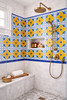 Yellow cobalt talavera medallion tile featured in a bathroom shower with visible joints and clean layout