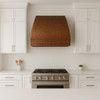 Handcrafted hand-hammered under cabinet copper range hood in a transitional kitchen