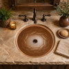 Braided round copper bathroom sink featured in a rustic house interior with natural textures enhancing its braided relief pattern