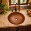 Mexican braided copper bathroom sink placed in a Mexican kitchen scene complementing tile surfaces and traditional rustic elements