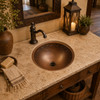 Vine border round copper sink placed in a rustic entry washstand highlighting its vine motif and handcrafted texture
