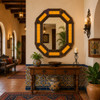 Octagonal tin mirror frame with amber talavera tile accents in hacienda hallway interior