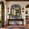 Octagonal decorative tin mirror with blue talavera flower tiles displayed in a Spanish Revival entry hall