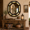 Octagonal decorative tin mirror with yellow blue white talavera tiles beside rustic wood console