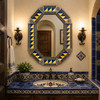 Octagonal decorative tin mirror with blue yellow talavera tiles above Spanish vanity sink