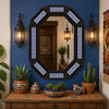 Decorative octagonal hacienda mirror with blue talavera accents on colorful accent wall
