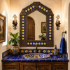 Handcrafted arch talavera sun moon tin wall mirror above a rustic talavera sink vanity