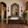 Handcrafted arch tin mirror with blue triangle tiles in a Spanish Revival hallway