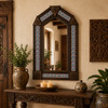 Handcrafted arch tin mirror with hacienda talavera tilework near carved wood decor