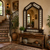 Handcrafted arch talavera tin mirror frame with floral tile accents beside staircase