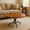 Round handcrafted copper table top on living room coffee table, hammered surface with warm patina and visible texture
