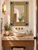 Yellow floral Talavera mirror above a vanity in a bright powder room with warm artisan details