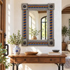 Talavera tile mirror above a wood console in a bright entryway with white plaster and ceramic accents