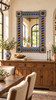 Talavera tile mirror above a long wood buffet in a bright dining room with neutral walls and dining chairs