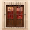 Black wrought iron window guard with scroll top design installed on the window with cantera stone surand