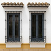 Andalusian black wrought iron window guards installed on a house exterior