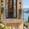 Wrought iron balcony railing with quatrefoil and scroll design at a lakeside residence