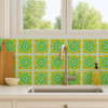 Mexican talavera tile green rope medallion decorating a bright kitchen backsplash with windows and natural light