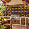 Mexican talavera tile yellow medallion in a garden kitchen with greenery and rustic finishes.