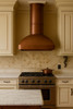 Minimalist smooth custom copper range hood in a traditional style kitchen