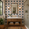 Navy daisy mexican tile used as a bathroom accent strip next to brass fixtures