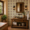 Mexican talavera tile in yellow and blue floral adding artisan color to a rustic bathroom wall.