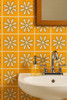 Handpainted daisy talavera tile in yellow and white colors on a bathroom wall accent